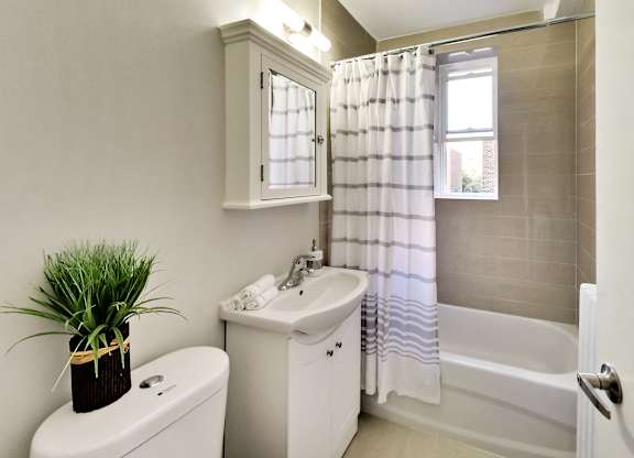 A white bathroom with a toilet, sink, and bathtub.