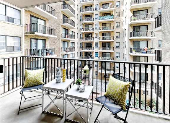 a balcony with a table and chairs and an apartment building