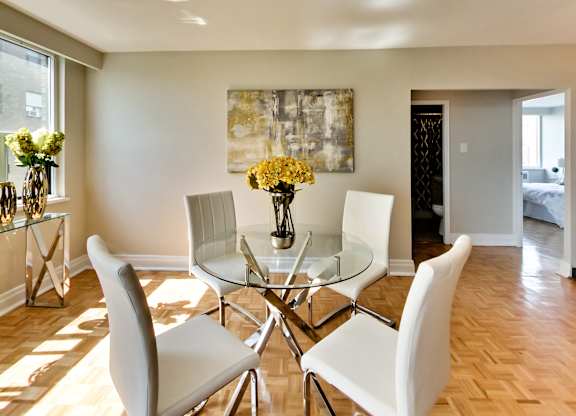 a dining room with a glass table and white chairs