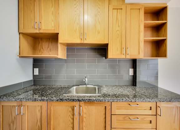 a kitchen with wood cabinets and granite counter top and a sink