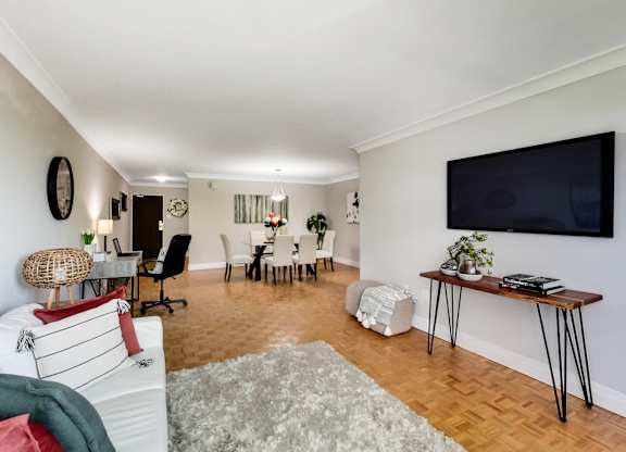 A living room with a white couch and a wooden floor.