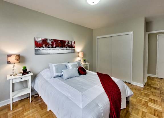a bedroom with a white bed and a red blanket