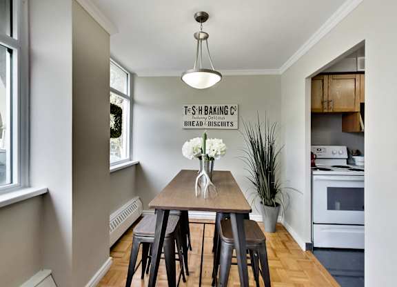 A kitchen with a table and chairs and a sign that says