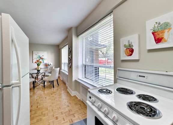 a kitchen with a stove and a refrigerator and a dining room