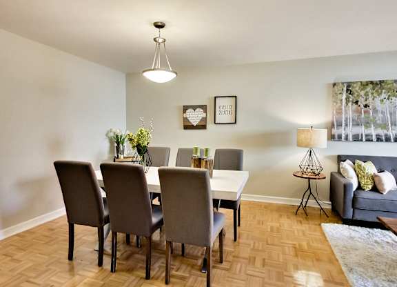 A dining room with a table and chairs.