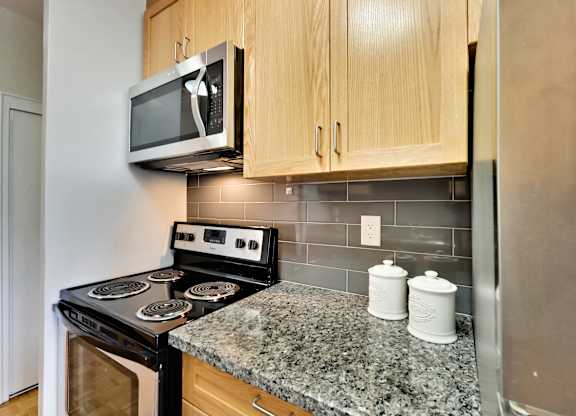 an updated kitchen with granite countertops and a stove and microwave