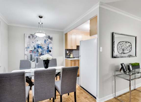 a dining room with a table and chairs and a refrigerator
