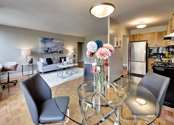 a living room and dining room with a glass table and chairs