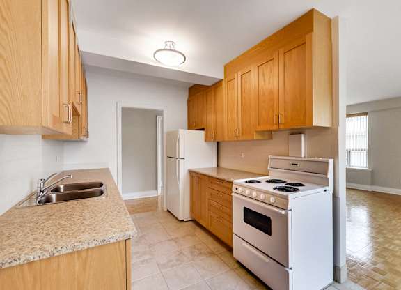 a kitchen with white appliances and wooden cabinets