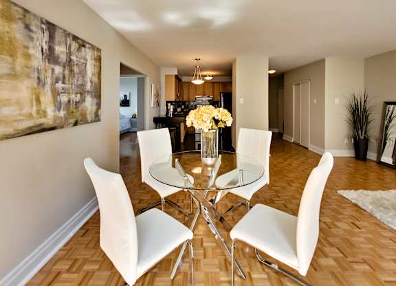 a dining room with a glass table and white chairs