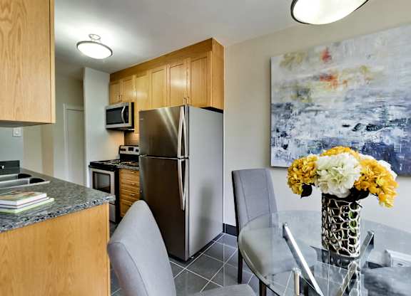 a kitchen and dining room with stainless steel appliances and a table with flowers