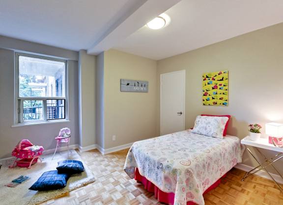 a bedroom with a bed and a desk and a window