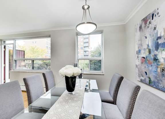 a dining room with a glass table and chairs