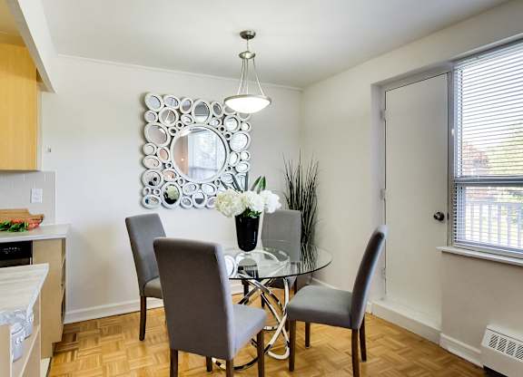 a dining room with a glass table and chairs and a mirror