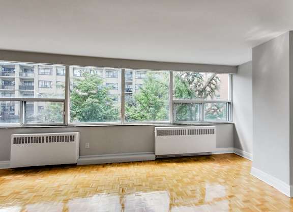 an empty living room with a large window and wood floors