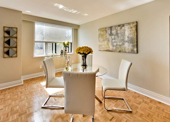 a dining room with a table and chairs and a window