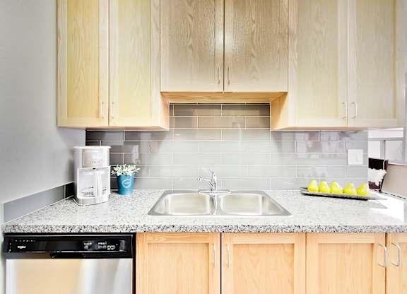 a kitchen with wooden cabinets and granite counter top and a sink