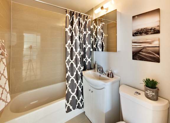 a bathroom with a shower curtain and a toilet and a sink