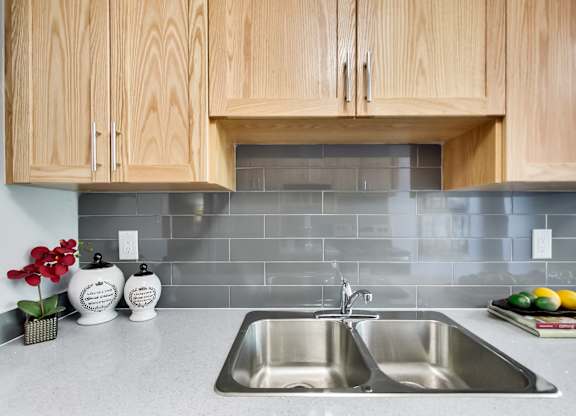 A kitchen with a sink and wooden cabinets.