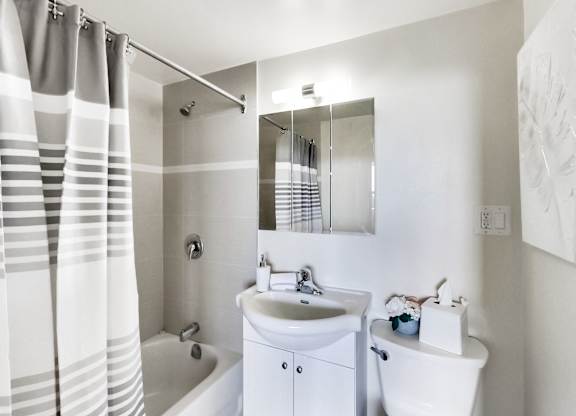 A white bathroom with a sink, toilet, and bathtub.