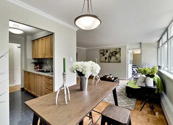 A kitchen with a wooden table and a vase of white flowers on it.