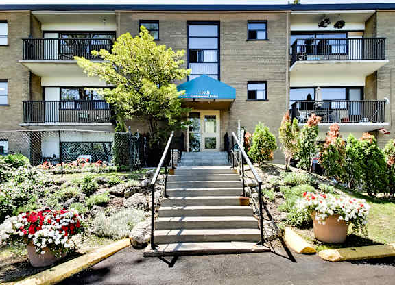 A building with a blue awning and a staircase leading to the entrance.