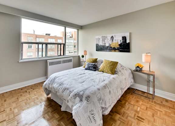 a bedroom with a bed and a large window