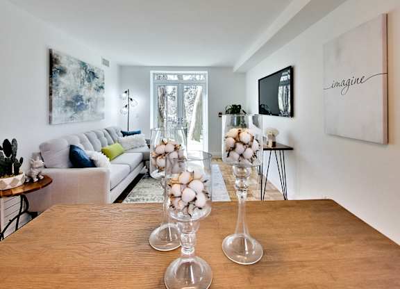 a living room with a wooden table with glass vases and a couch