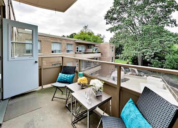 a balcony with a table and chairs and a window