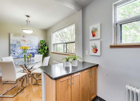 A kitchen with a table and chairs and a painting on the wall.