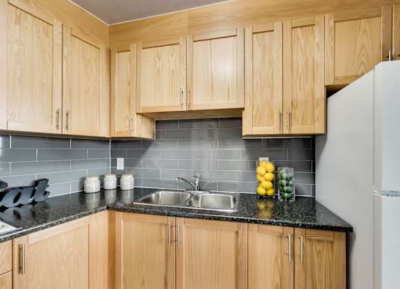a kitchen with wooden cabinets and a sink and a refrigerator