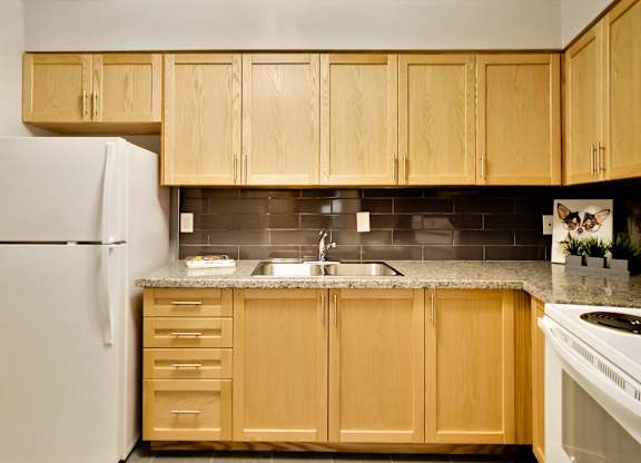 a kitchen with wooden cabinets and a white refrigerator