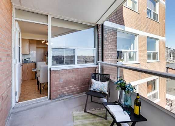 A balcony with a table and chairs overlooking a building.