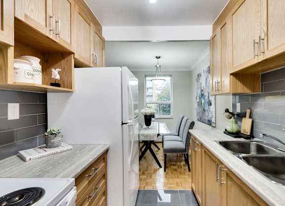 a kitchen with wooden cabinets and white appliances and a dining room table