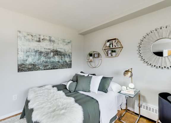 A bedroom with a large bed and a painting on the wall.