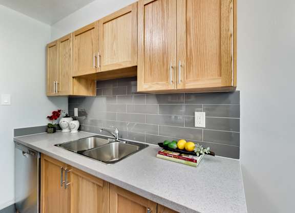A kitchen with wooden cabinets and a grey countertop.