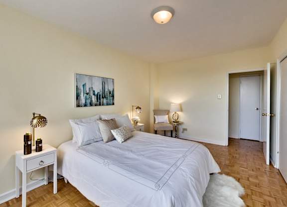 A bedroom with a large bed and a painting on the wall.