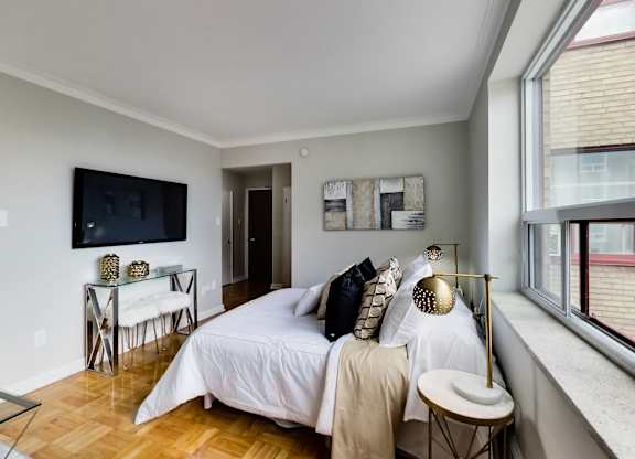 a bedroom with a bed and a tv on the wall