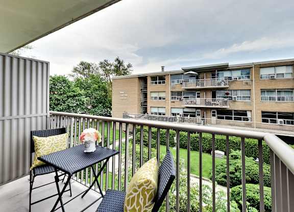 a balcony with a table and chairs on it