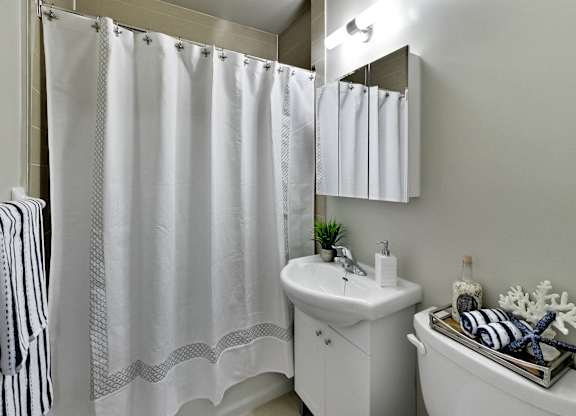 a bathroom with a shower and a sink and a toilet