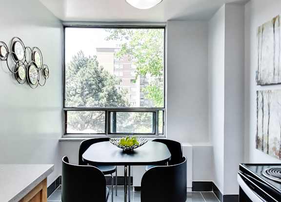 A dining room with a table and chairs.