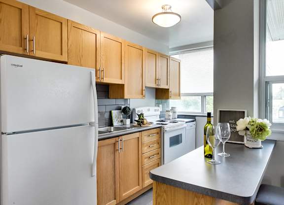 a kitchen with wood cabinets and white appliances and a counter top with a white refrigerator