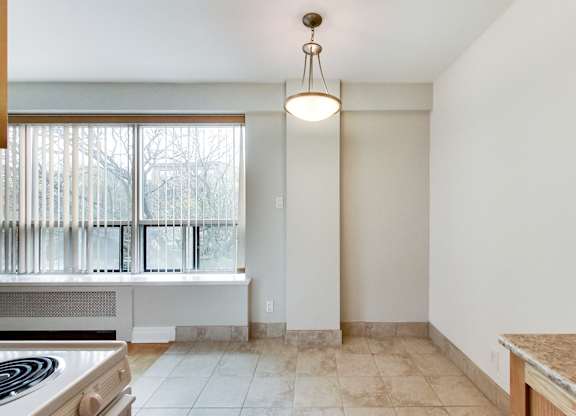 an empty kitchen with a window and a stove and a counter top