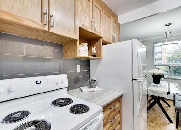 a kitchen with white appliances and wooden cabinets and a white refrigerator