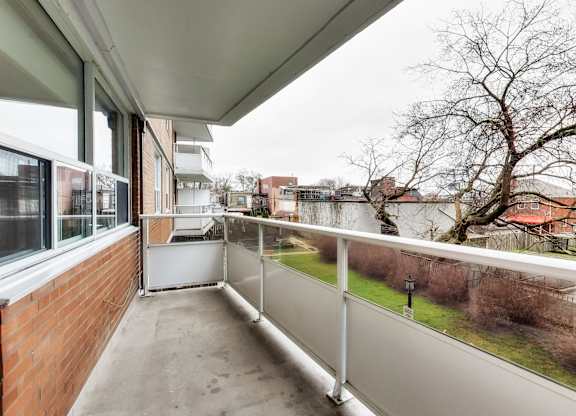A balcony with a white railing and a view of a residential area.