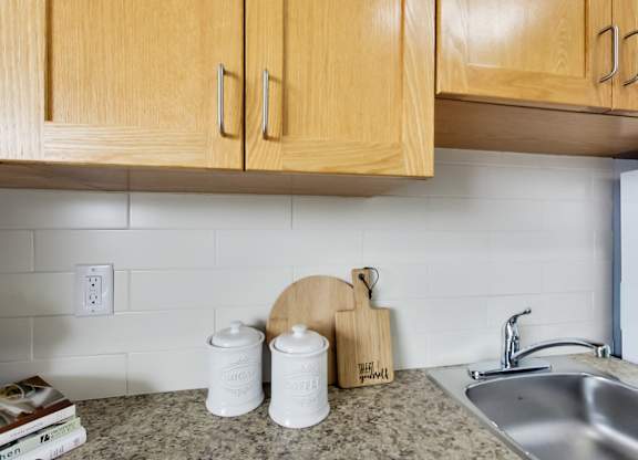 A kitchen counter with a cutting board and two containers on it.