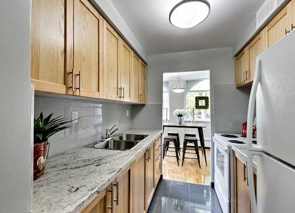 A kitchen with wooden cabinets and a marble countertop.