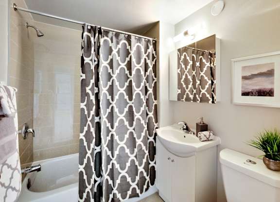 a bathroom with a shower and a sink and a toilet