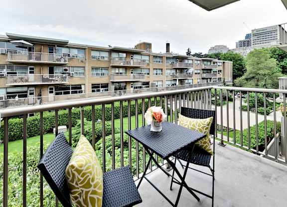 a balcony with a table and chairs and a view of an apartment building