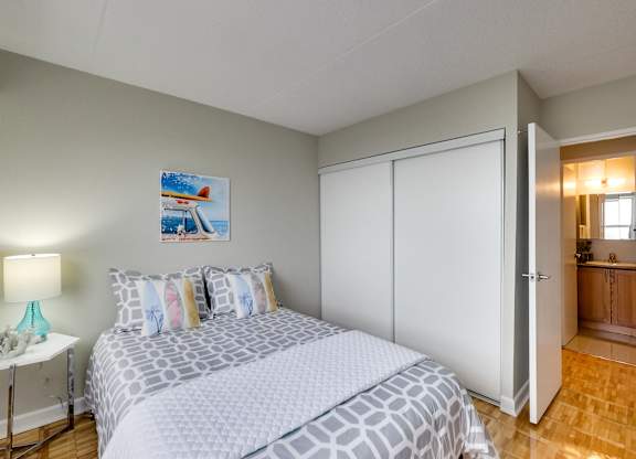 a bedroom with a bed and a mirrored wall